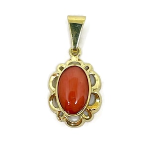 Red coral pendant. Natural red coral mounted in a gold frame.