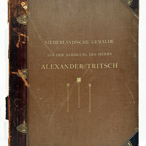 May include: A brown book with a gold title that reads "Niederländische Gemälde aus der Sammlung des Herrn Alexander Tritsch".
