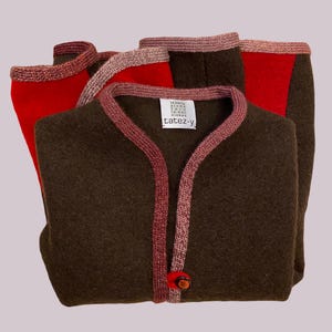 Può includere: Un cardigan marrone con un bordo rosso e rosa. Il cardigan ha una chiusura con un solo bottone e un'etichetta che recita "tatez-y".