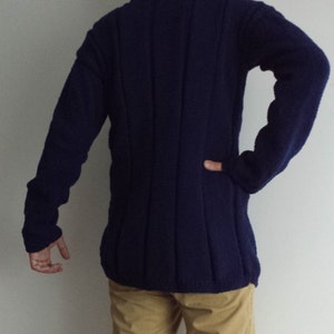May include: A dark blue knitted sweater with a long sleeve and a ribbed texture.