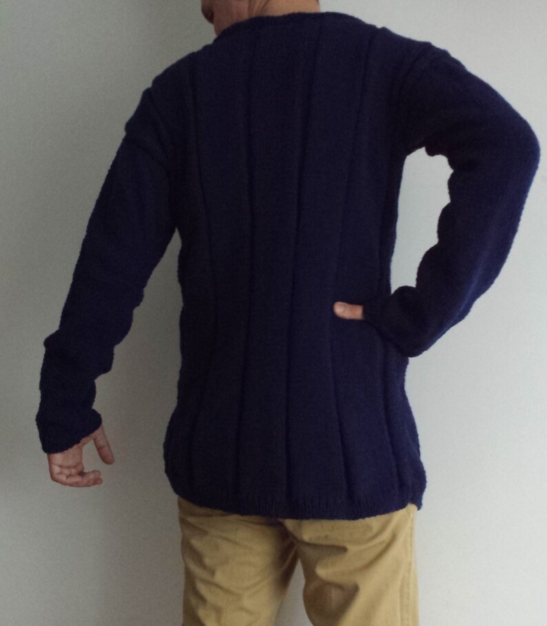 May include: A dark blue knitted sweater with a long sleeve and a ribbed texture.