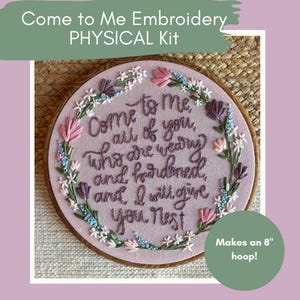 May include: A physical embroidery kit with the text "Come to Me" embroidered on a pink fabric. The embroidery is framed in an 8-inch hoop and features floral accents in pink, purple, and blue. The kit includes the phrase "Come to me, all of you, who are weary and burdened, and I will give you rest."