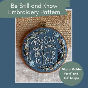 May include: A blue embroidery hoop with the text "Be Still and Know that He is God." The embroidery is surrounded by a floral design. The text "Digital Guide for 6" and 8.5" hoops" is also present.