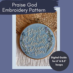 May include: Blue embroidery hoop with white lettering that reads "Praise God from whom all blessings flow". The hoop is surrounded by a wreath of blue and white flowers. The hoop is 15.2 cm in diameter.