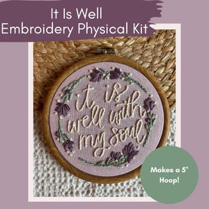 Pode incluir: Um kit de bordado físico com o texto "It Is Well" e "well with my soul" bordado em tecido rosa. O bordado está num bastidor de madeira que faz um aro de 12,7 cm. O kit inclui um círculo verde que diz "Makes a 5" Hoop!"