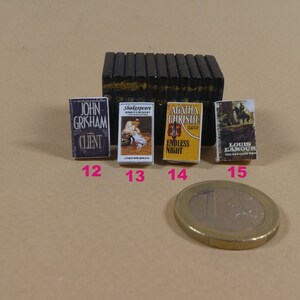 May include: Four miniature paperback books with different titles and authors. The books are arranged in a row from left to right. The titles are "The Client" by John Grisham, "A Midsummer Night's Dream" by Shakespeare, "Endless Night" by Agatha Christie, and "The Revenge Man" by Louis L'Amour.