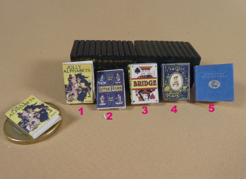 May include: Five miniature books with colorful covers. The books are titled "A Jolly Alphabets", "Little Folks", "Bridge", "Mrs. Pig's Green Gown", and "Painting Miniature", respectively.