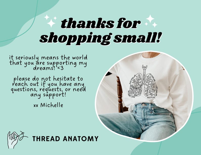 May include: A white t-shirt with a black line drawing of lungs with text inside each lung. The text reads "I breathe in love" and "I exhale kindness". The t-shirt is on a person wearing blue jeans and sitting on a wooden chair. The background is a light blue and green abstract design with the text "thanks for shopping small!" and "it seriously means the world that you are supporting my dreams! <3 please do not hesitate to reach out if you have any questions, requests, or need any support! xx Michelle THREAD ANATOMY".