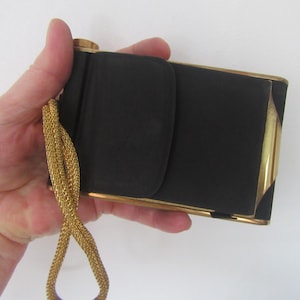 May include: A white ceramic mug with a black handle and the text "But First, Coffee" in a bold, black font. The mug is set against a blurred background, suggesting a cosy setting.