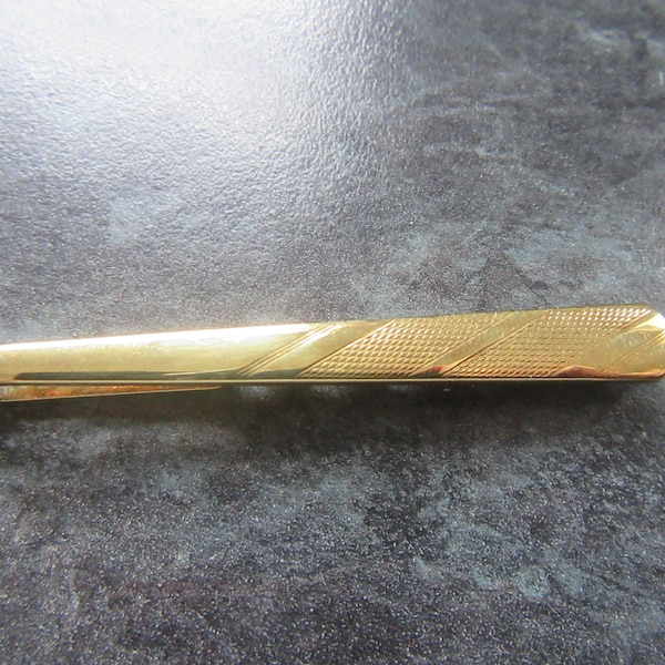 Vintage tie clip slide bar. West Germany stamped. Shiny gold tone. In the style of a tie.