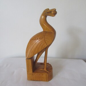 Mythical prehistoric wooden carved bird holding an egg in its mouth.Handcarved figurine home,office decoration.