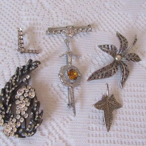 Vintage Diamonte Brooches. Ocean plant. Letter "L"  Bar/pin. Celtic yellow stone. Pearl/purple flower, marcasite leaf.