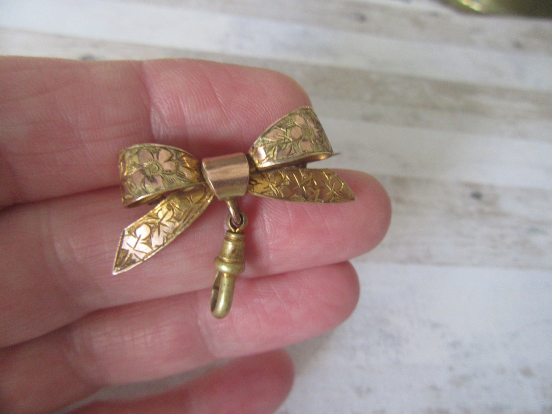 Antique bow brooch with dog clip.Watch fob.Gold/copper tone metal.Bow locket, charm holder brooch.