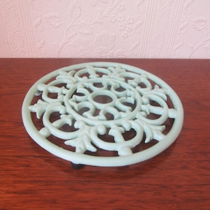 Vintage gjutjärnsunderlägg i ljusgrönt. Varma stekpannor för kök, vattenkokare.