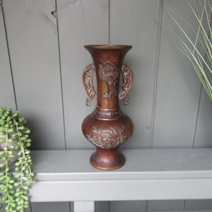 Vintage bronze-brass vase. Raised in relief birds and flowers design. Home office decoration, ornament.