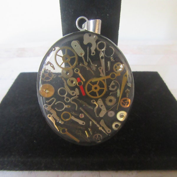 Steampunk oval resin watch parts in a sterling silver frame, pendant/necklace. Gears and other watch parts encased in clear acrylic resin.