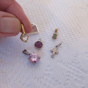 Peut inclure: Un ensemble de six petits pendentifs avec différentes pierres précieuses. Les pendentifs sont en or et en argent et présentent des pierres claires, roses, violettes et vertes.