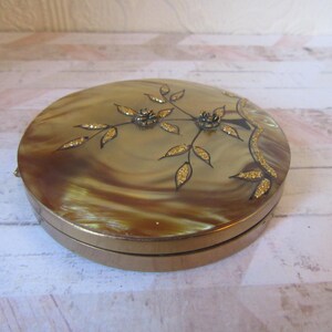 Vintage Rare lucite compact with raised golden flakes mosiac leaves & raised metal flowers. Very good condition.Unusual powder dial inside.