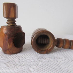 Peut inclure: Deux casse-noix en bois. L'un est de style traditionnel avec un corps rond et une poignée avec une série de boutons. L'autre est de style plus moderne avec un corps hexagonal et un dessus en forme de vis.
