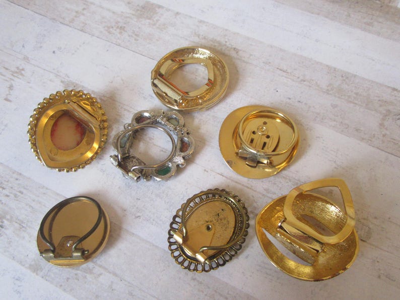May include: Seven gold-toned metal belt buckles with various designs. Some buckles have a decorative, ornate design, while others are more simple. The buckles are all in good condition and would be a great addition to any belt collection.