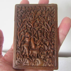 Antiguo tarjetero de madera de sándalo tallado a mano de alrededor de 1900. Escena diferente en cada lado. Diseño y estilo oriental. Monos, pájaros, hombres con pistola y arco.