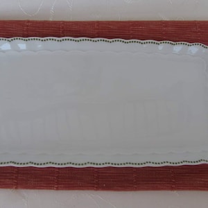 May include: White rectangular serving tray with a scalloped edge and a green and white floral design.