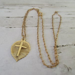 Vintage German cross/crucifix pendant on a gold-plated chain. Gold-tone cross on an enamel effect leaf shape.