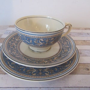 May include: A vintage teacup and saucer set with a blue and white floral pattern. The cup and saucer have a gold trim and a delicate design.