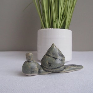 Handskulpturerad lerasnigel. Grön/grå/svart keramikväxtkompis, kreativ prydnad i älvträdgården. Med tillverkarens märke på basen.