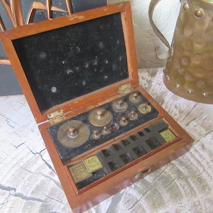 Antique brass apothecary weights. L Oertling Ltd London cased scale weights. Wood case velvet lined. Not Complete.
