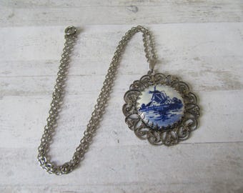 Vintage delft blue Dutch pendant necklace. Silver tone filigree mount ceramic dutch scene with silver tone chain.