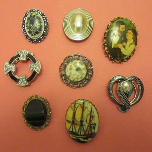 Peut inclure: Assortiment de huit broches vintage de styles et de couleurs variés. Les broches présentent une variété de motifs, notamment un motif floral, une perle, un couple, un navire, un cœur, une pierre et un cercle avec des strass.