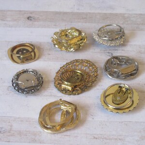 K&ouml;nnte beinhalten: Acht Ohrringverschl&uuml;sse im Vintage-Stil in Gold- und Silbert&ouml;nen. Die Verschl&uuml;sse sind alle in verschiedenen Stilen gehalten und weisen komplizierte Designs auf.