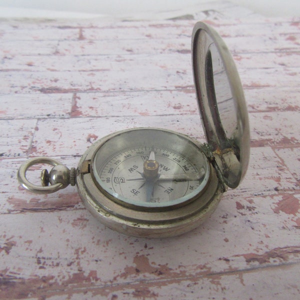 Antique 1920s magnetic pocket compass in a pocket watch style case. Top ring for attaching to a chain or belt.