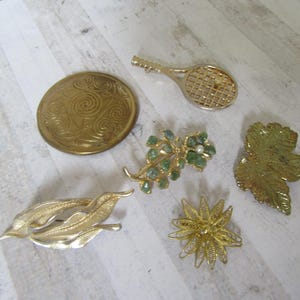 Collectie vintage broches x6. Vleermuis en parel. Esdoornblad. Schild. Draadwerkbloem. Groene stenen en parel. Vloeiende bladeren.