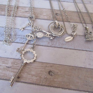 Vintage Collection of 4 silver metal pendant necklaces.Owl, 4 point with rhinestone, 5 rings "Jon Richard". 5 Keys "Avon"  Silvertone metal.