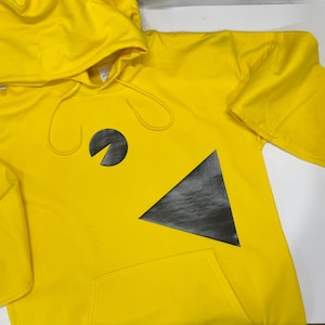 Könnte beinhalten: Ein leuchtend gelber Kapuzenpullover mit einem schwarz-grauen Grafikdesign. Das Design umfasst einen schwarzen Kreis mit einem gebogenen Abschnitt und ein schwarzes Dreieck. Der Hoodie hat eine Kapuze und eine Vordertasche.
