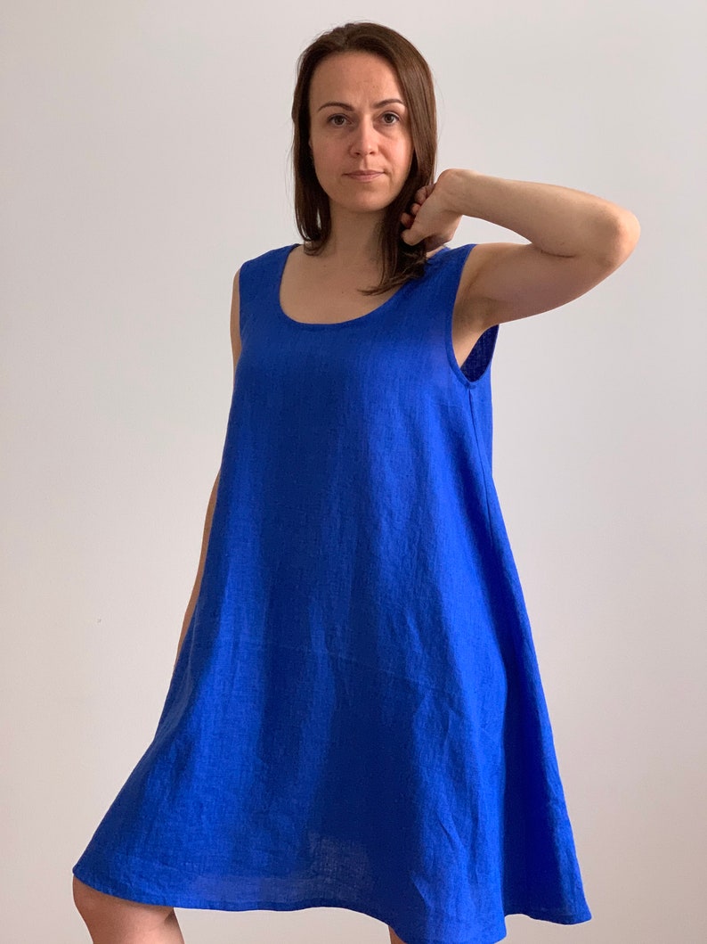 Puede incluir: Un vestido de lino azul real sin mangas, con cuello redondo y un corte holgado y fluido.