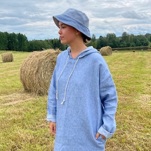A reversible linen bucket hat in soft blue and pastel tones, handmade and ready to ship in one unique piece.