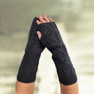 May include: A pair of black fingerless gloves with a cable knit pattern.