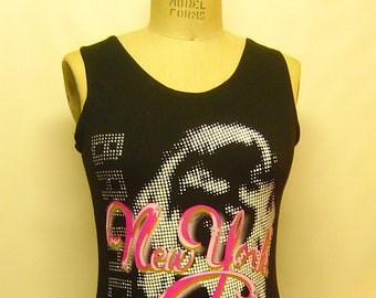 May include: Black tank top with a white and black graphic print of a woman's face with the text "New York 42nd Street" in pink and gold lettering. The tank top has a black lace trim at the bottom.