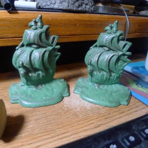 May include: A white ceramic mug with a black handle and the text "But First, Coffee" in a handwritten style. The mug is on a white surface. The mug is approximately 4 inches tall.