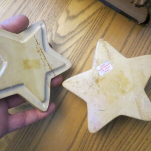 May include: Two beige ceramic star-shaped trinket boxes. The larger star has a sticker on the back that reads "Genius Home Products No. 14811 China".