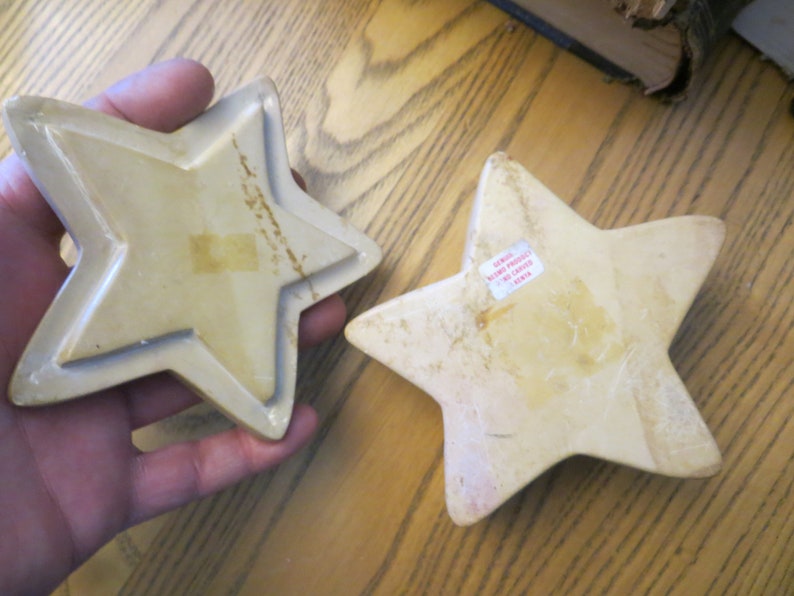 May include: Two beige ceramic star-shaped trinket boxes. The larger star has a sticker on the back that reads "Genius Home Products No. 14811 China".