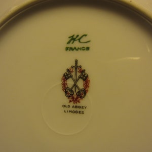 May include: A white porcelain plate with a green and red logo that reads "Old Abbey Limoges" and "HC France".