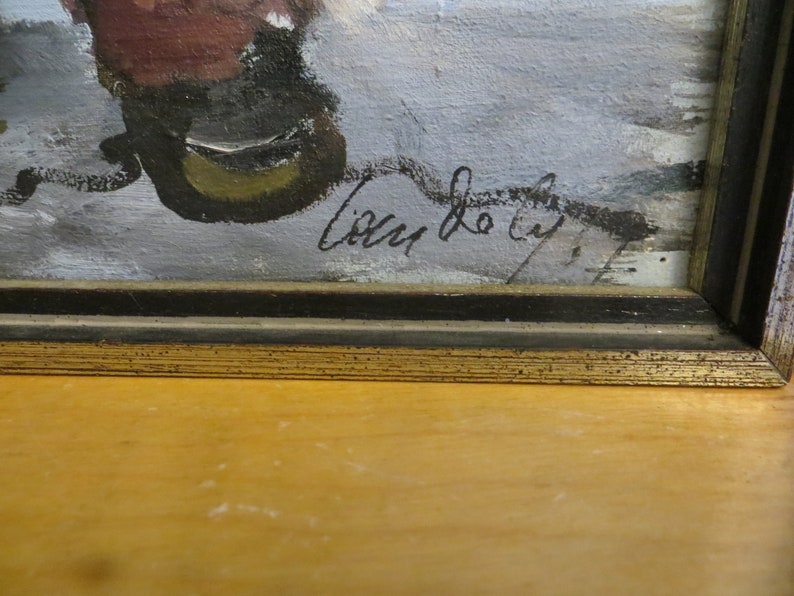 May include: A framed painting with a black frame and a gold trim. The painting is of a winter scene with a signature in the bottom right corner that reads "Lilly de Lyf."
