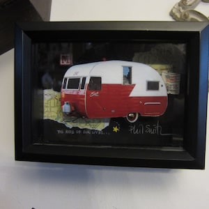 May include: A framed artwork featuring a vintage red and white camper van with the text "The Ride of Our Lives..." and the artist's signature "Phil Smith".