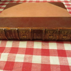 May include: A brown leather-bound book with gold lettering on the spine. The title is "A History of the Theatre" by J.A. Perkins and C.L.  Dolby.