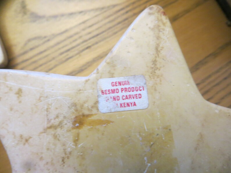 May include: A white star-shaped carved stone sculpture with a label that reads "GENUINE BESMO PRODUCT HAND CARVED IN KENYA".