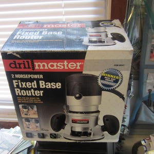 May include: A boxed drill master 2 horsepower fixed base router. The box is black, red, and silver, with the product name and features prominently displayed. A "Winner! Best Buy Award" sticker is visible.